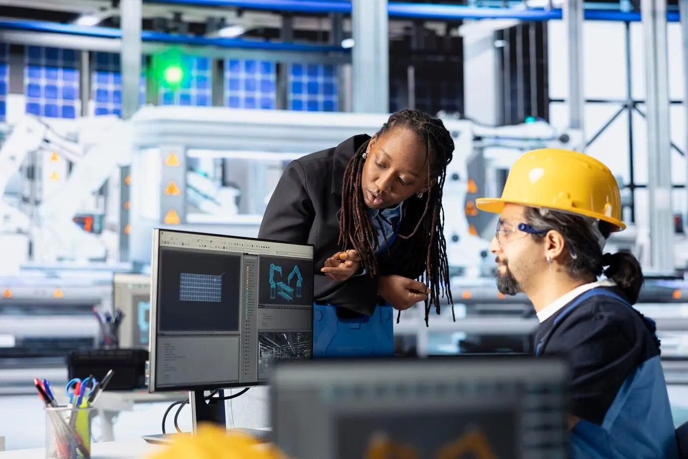 Ein Mann und eine Frau arbeiten in einer Photovoltaikfabrik und optimieren den Produktionsfluss.