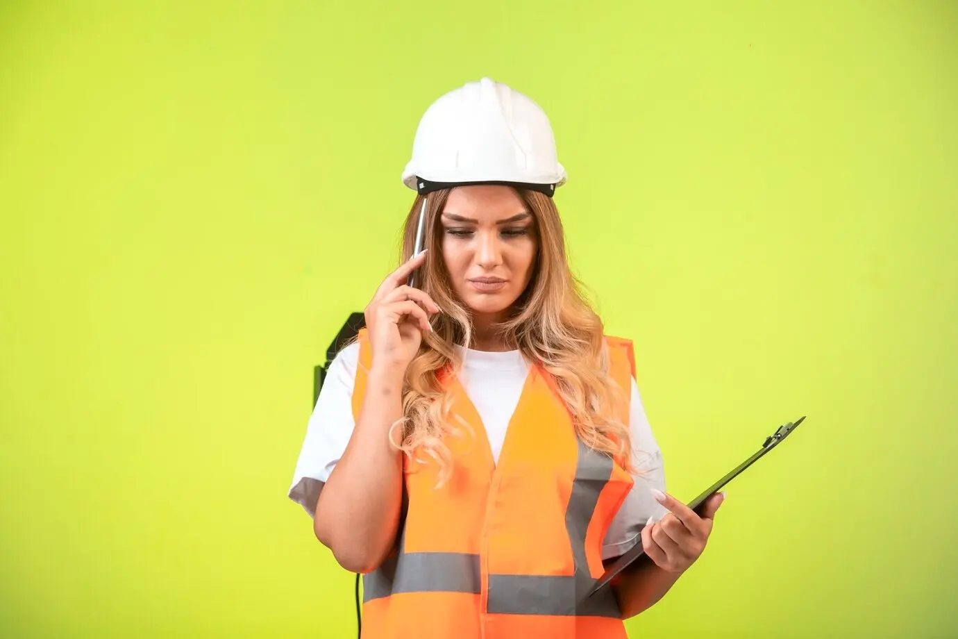 Eine Ingenieurin mit weißem Helm und Ausrüstung hält die Checkliste und versucht, sich zu erinnern.